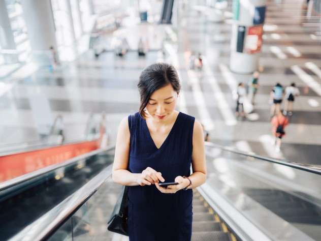 View a woman with a smartphone on an escalator