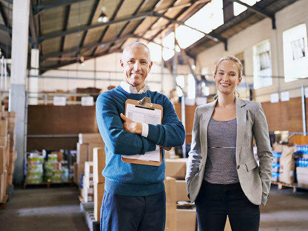 Woman and man taking inventory inside a warehouse