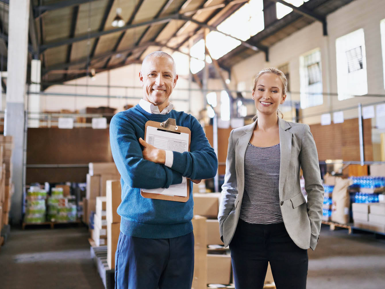 Woman and man taking inventory inside a warehouse